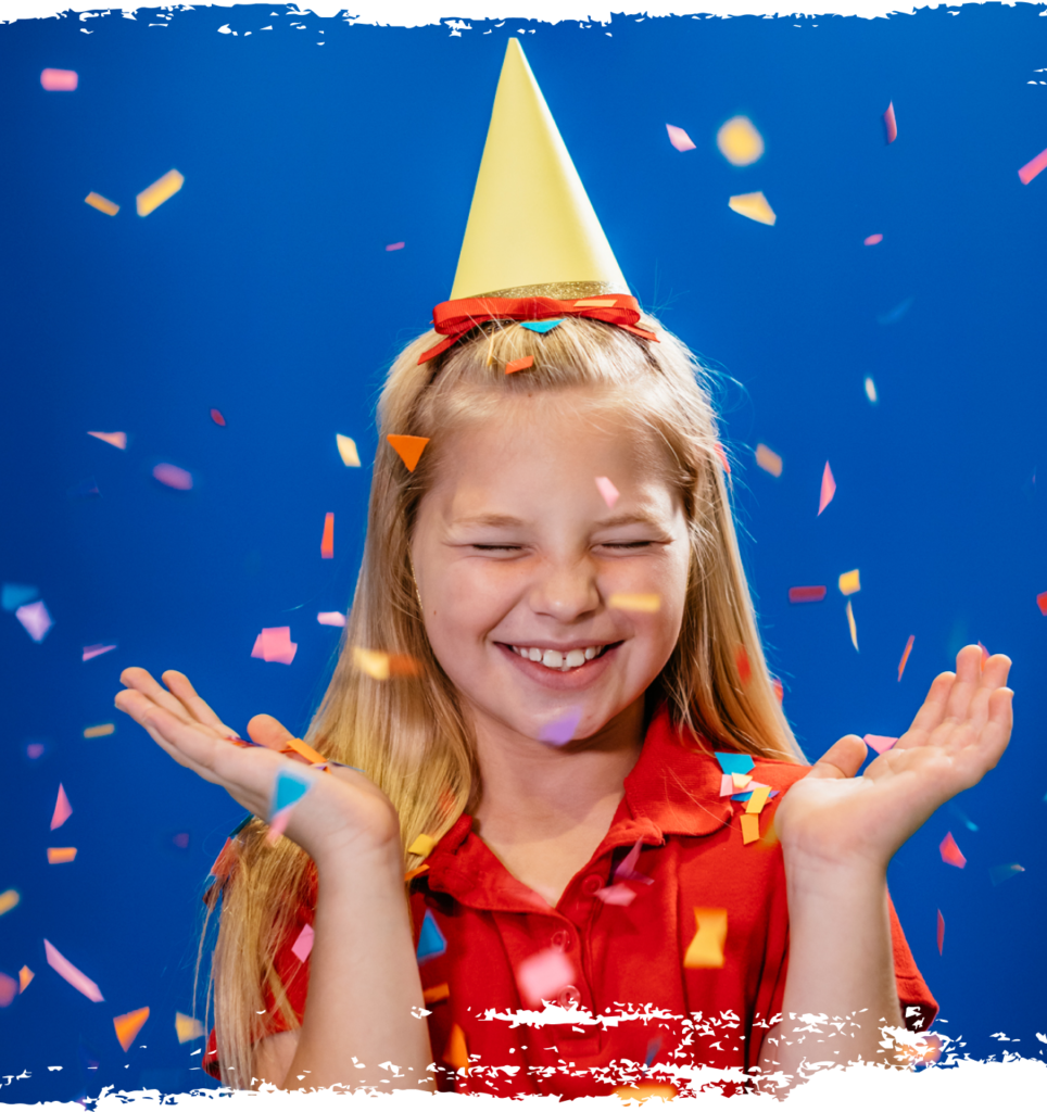 Blonde girl in a birthday hat with confetti