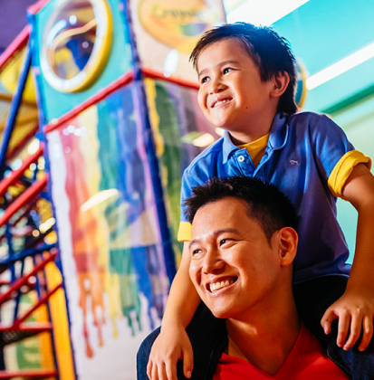 Dad with son on shoulders at Crayola Playground